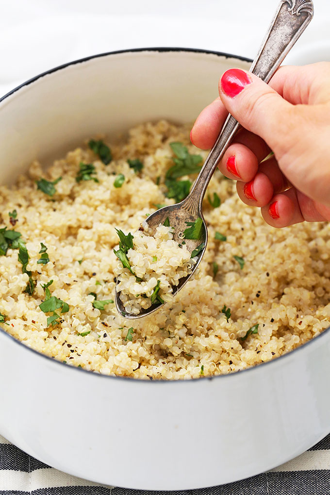 Close up of perfectly cooked, fluffy quinoa in a white pot.