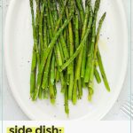 Roasted asparagus spears on a white serving plate