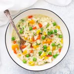 A Bowl of Gluten Free Dairy Free Chicken Vegetable Risotto with a spoon dipped in.
