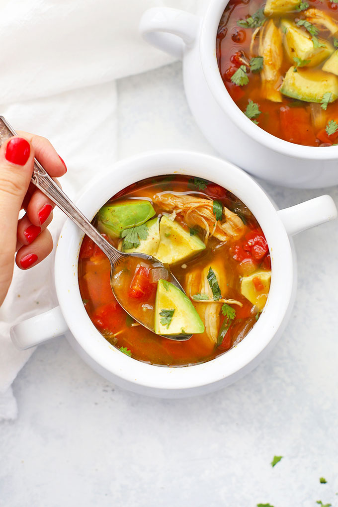 white crock of Slow Cooker Pumpkin Taco Soup topped with avocado