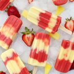 Overhead view of strawberry pineapple lava flow popsicles on a platter of ice
