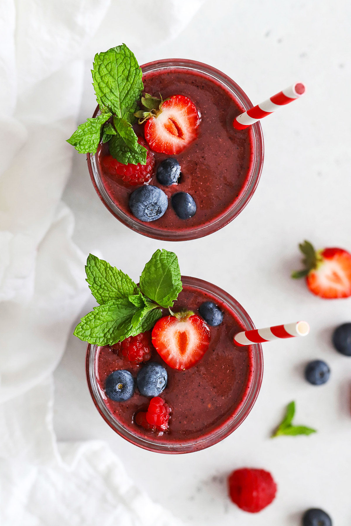 overhead view of berry smoothie topped with fresh berries and fresh mint