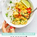 Setting down a bowl of coconut shrimp curry on a white background with text overlay that reads "Paleo + Whole30 Friendly Coconut Shrimp Curry"