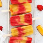 raspberry peach popsicles on a tray with ice