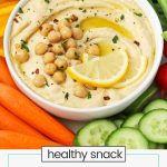 a bowl of homemade hummus surrounded by fresh vegetables