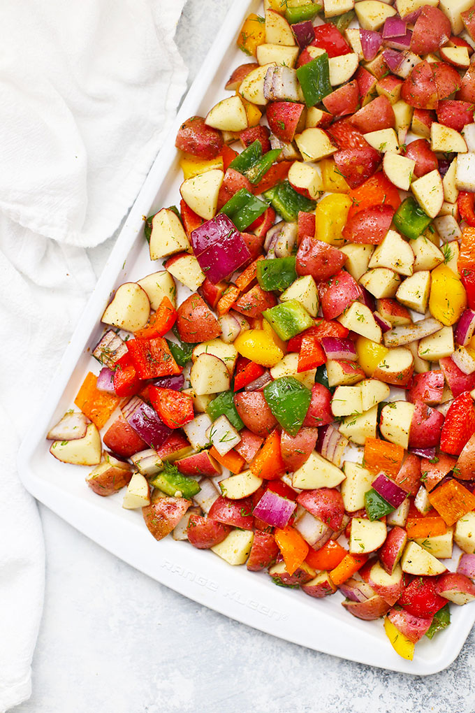Sheet pan of breakfast potatoes and veggies ready to go into the oven for roasting.