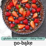 Overhead view of no bake chocolate berry tart on a dark background with text overlay that reads "gluten-free + vegan + dairy-free no-bake chocolate berry tart"