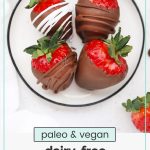 paleo chocolate covered strawberries on a black and white plate