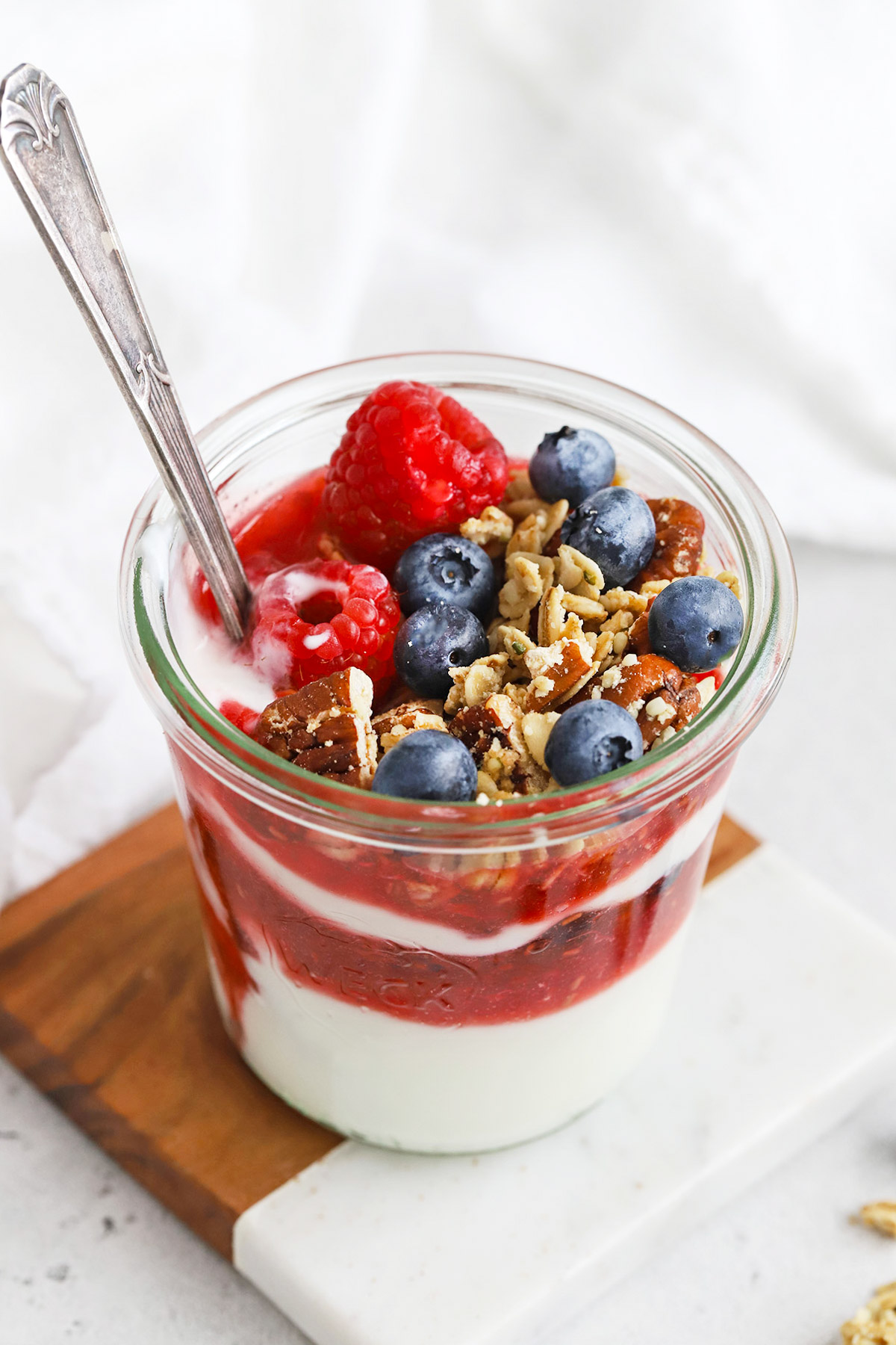 Front view of a yogurt and berry parfait made with homemade maple pecan granola