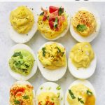 Close up image of 12 flavors of paleo deviled eggs on a white background with text overlay that reads "Paleo + Whole30. 12 Flavors of Perfect Deviled Eggs"