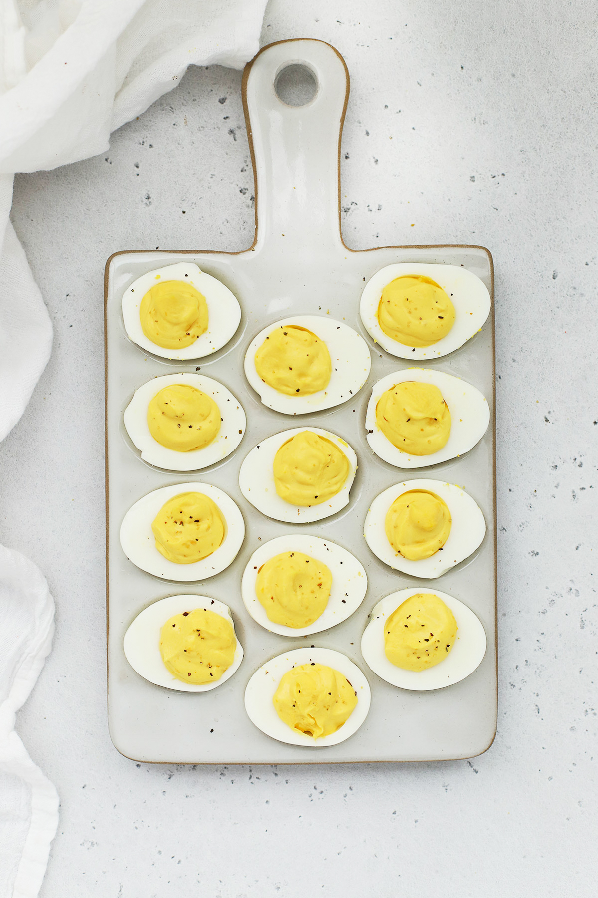 Overhead view of classic deviled eggs on a white egg platter