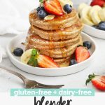 Close up Front view of a stack of blender banana oatmeal pancakes topped with sliced bananas, fresh berries, and syrup with text overlay that reads "gluten-free + dairy-free blender banana oatmeal pancakes"