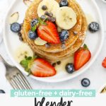 Overhead view of a stack of blender banana oatmeal pancakes topped with sliced bananas, fresh berries, and syrup with text overlay that reads "gluten-free + dairy-free blender banana oatmeal pancakes"