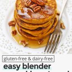 Front view of healthy pumpkin oatmeal pancakes with maple syrup and pecans with text overlay that reads "gluten & dairy-free blender pumpkin oatmeal pancakes: quick + healthy + cozy"