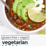Overhead view of two bowls of vegan black bean soup topped with plain yogurt, sliced avocado, cilantro, and lime with text overlay that reads "gluten-free + vegan vegetarian black bean soup: warm + cozy + healthy"