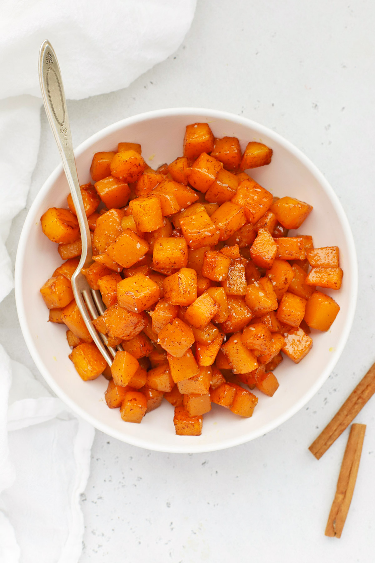 Overhead view of cinnamon roasted butternut squash in a white bowl