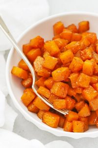 Front view of cinnamon roasted butternut squash in a white bowl