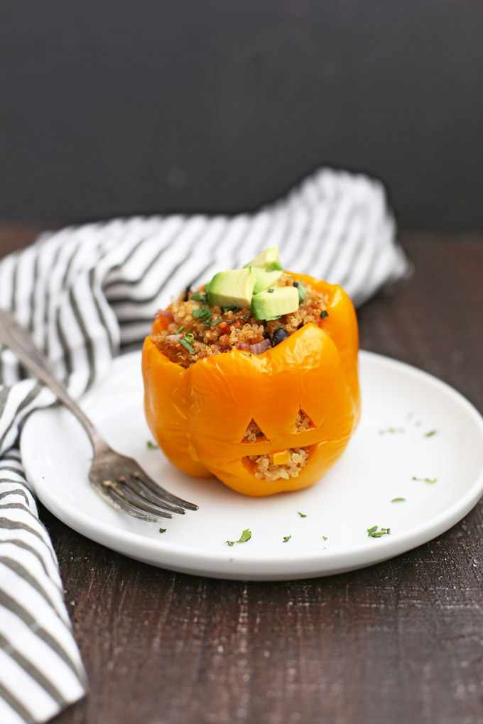 Front view of a Taco Quinoa Stuffed Pepper Jack O'Lantern on a plate with a fork. 