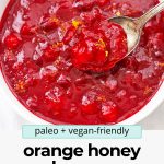 Overhead view of orange honey cranberry sauce with text overlay that reads "paleo & vegan-friendly orange honey cranberry sauce"