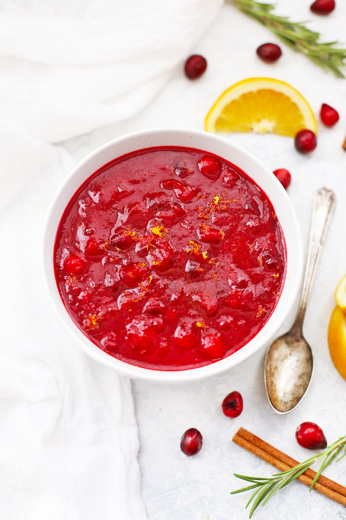 Close up Overhead view of paleo orange honey cranberry sauce in a white bowl on a white background