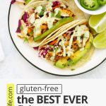 Overhead view of fish tacos with text overlay that reads "(gluten-free) The BEST EVER Fish Tacos with Honey Lime Slaw. So Many 5-Star Reviews!"