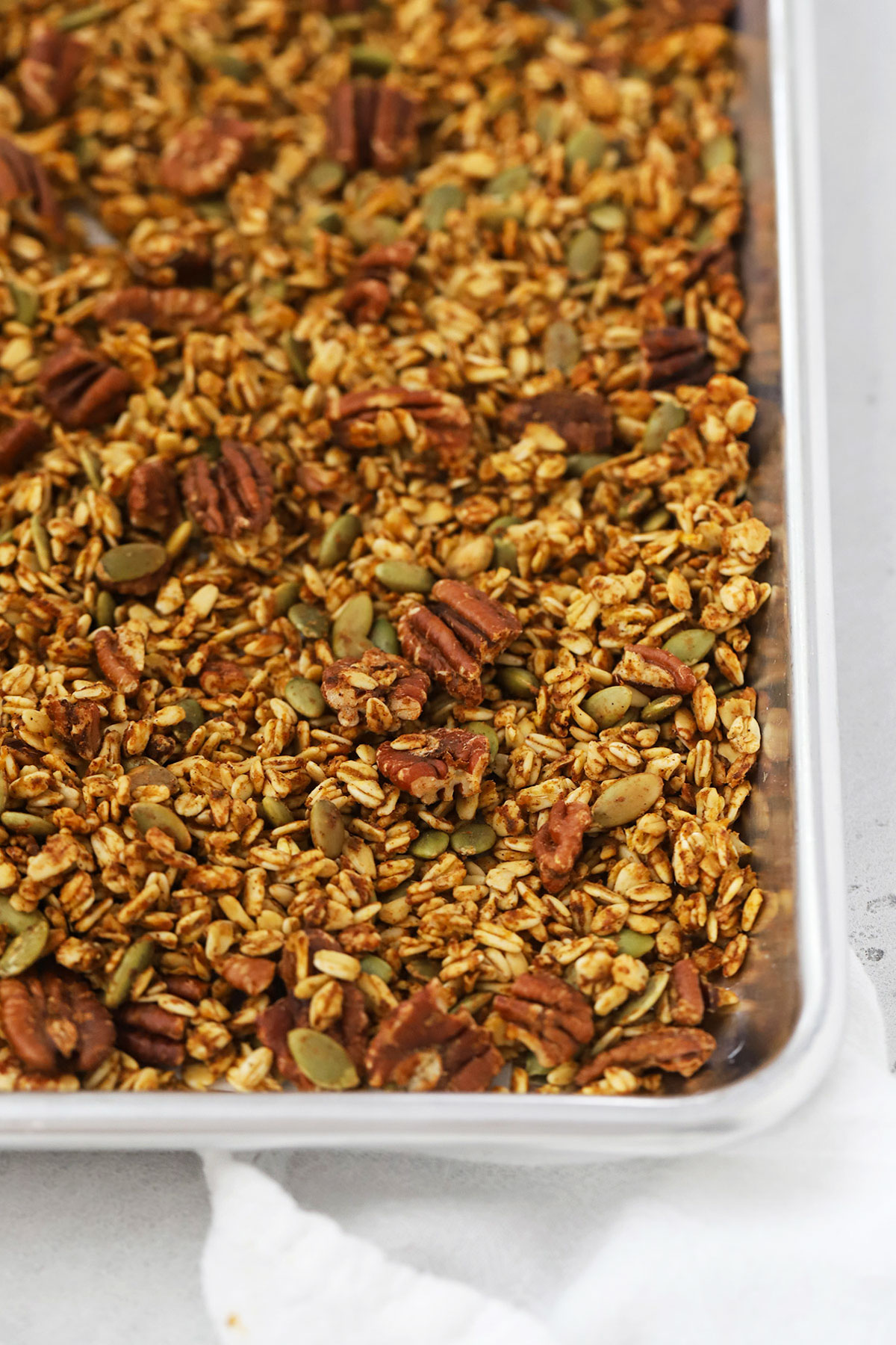 a sheet pan of homemade pumpkin granola with pecans and pumpkin seeds