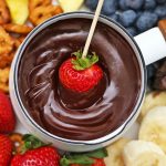 Strawberry being dipped into vegan chocolate fondue from OneLovelyLife.com