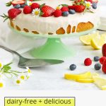 Front view of gluten-free lemon cake with lemon glaze topped with fresh berries with text overlay that reads "dairy-free + delicious gluten-free lemon cake with lemon vanilla glaze"