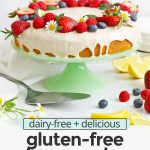 Front view of gluten-free lemon cake with lemon glaze topped with fresh berries with text overlay that reads "dairy-free + delicious gluten-free lemon cake with lemon vanilla glaze"