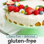 Close up front view of gluten-free lemon cake with lemon glaze topped with fresh berries with text overlay that reads "dairy-free + delicious gluten-free lemon cake with lemon vanilla glaze"