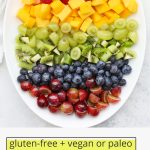 Overhead view of rainbow fruit salad with text overlay that reads "vegan + paleo rainbow fruit salad"