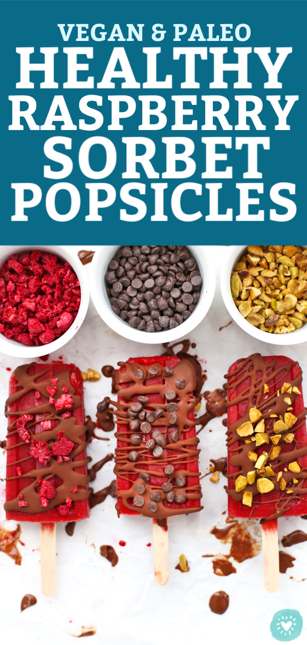 Paleo & Vegan Raspberry Sorbet Popsicles on a baking sheet, drizzled with chocolate shell and sprinkled with mini chocolate chips, chopped pistachios, and freeze dried raspberries with text that reads "Vegan & Paleo Raspberry Sorbet Popsicles"