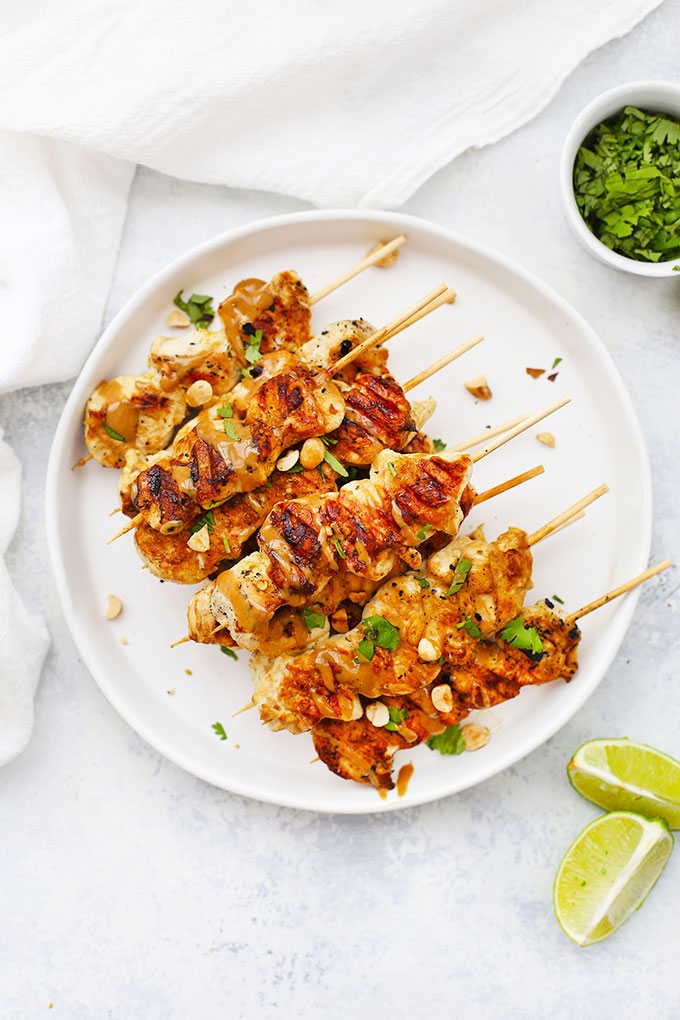 Chicken Satay Skewers drizzled with Peanut Sauce and garnished with cilantro and crushed peanuts