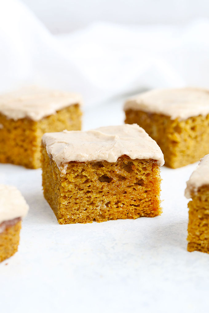 Slices of Gluten Free Pumpkin Cake with Cinnamon Frosting on a white background
