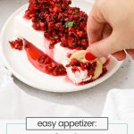 dipping crackers into cranberry salsa cream cheese appetizer