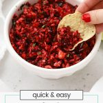 dipping tortilla chips in cranberry salsa