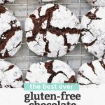 Close up Overhead view of Gluten Free Chocolate Crinkle Cookies on a cooling rack with text overlay that reads "the best ever gluten-free chocolate crinkle cookies. Dairy-free + so chocolatey!"