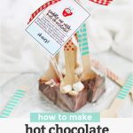 Four hot chocolate spoons wrapped in a clear treat bag with red ribbon and a free printable gift tag with text overlay that reads "How to make hot chocolate spoons +free printable gift tags"