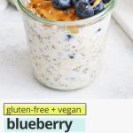 Front view of a jar of blueberry muffin overnight oats topped with fresh blueberries with text overlay that reads "gluten-free + vegan blueberry muffin overnight oats: a great meal prep breakfast"