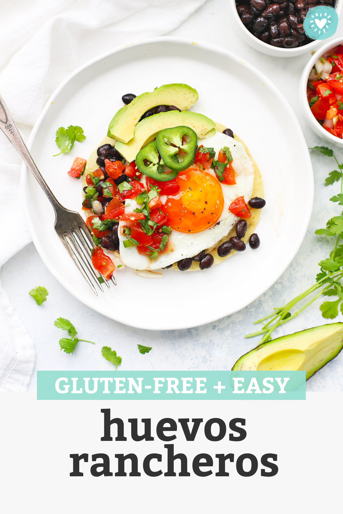 huevos rancheros on a white plate with fresh pico de gallo with text overlay that reads "gluten-free + easy huevos rancheros"