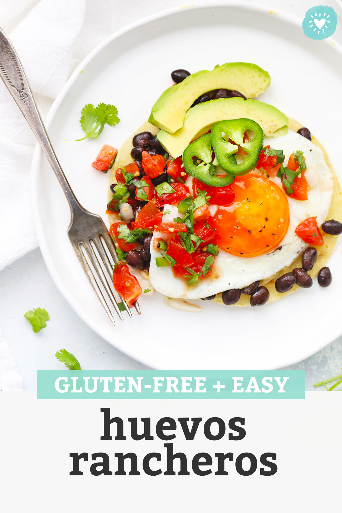 Close up view of huevos rancheros on a white plate with fresh pico de gallo with text overlay that reads "gluten-free + easy huevos rancheros"