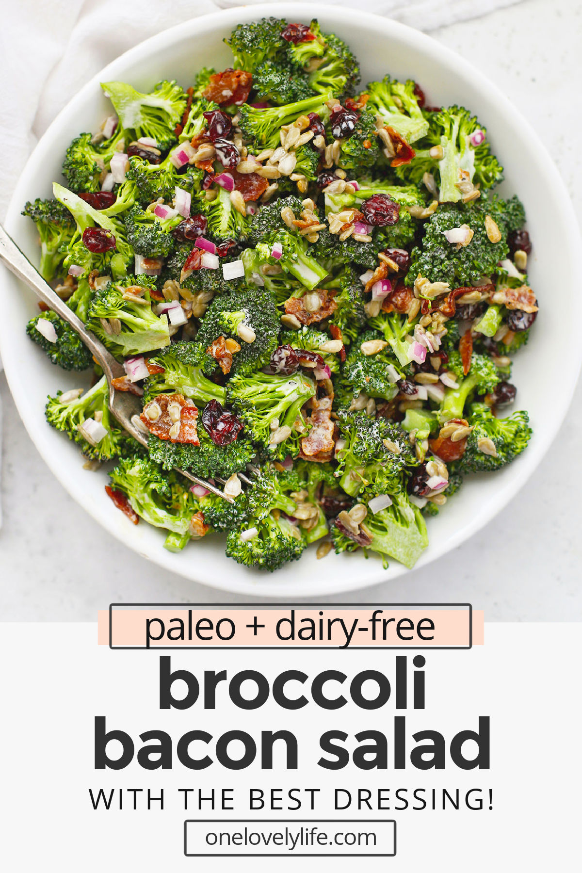 Overhead view of a bowl of broccoli bacon salad with text overlay that reads "paleo + dairy-free broccoli bacon salad with the best dressing!"