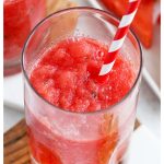 frozen watermelon slushie with a red and white striped straw