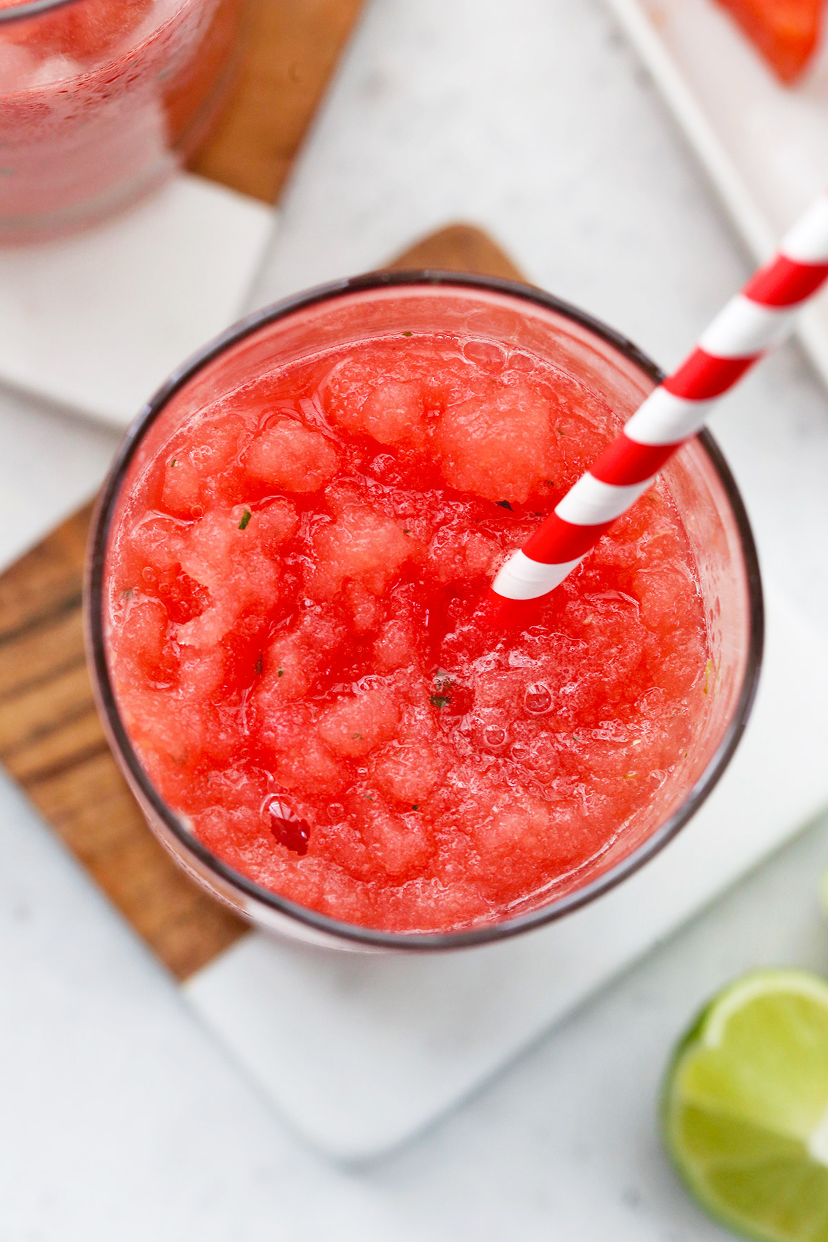 Close up view of Watermelon Slushie in a glass with red and white striped straw