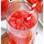 a frozen watermelon slushie with fresh lime and a red and white striped straw