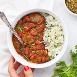 Serving Instant Pot Red Beans and Rice in a bowl garnished with fresh herbs
