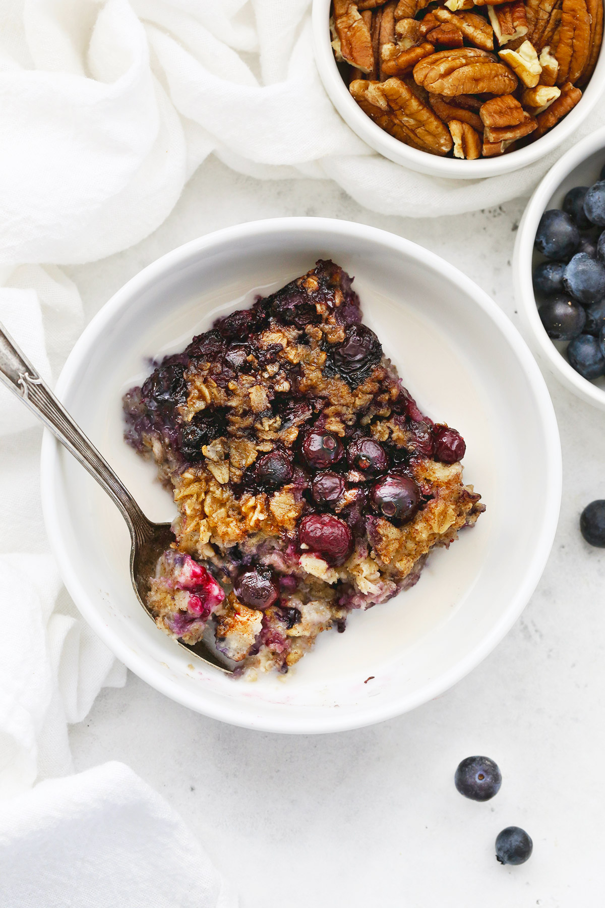 Slice of blueberry baked oatmeal in a bowl with almond milk. 
