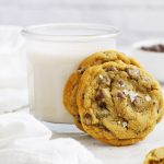 Gluten-Free Chocolate Chip Cookies leaning against a glass of almond milk