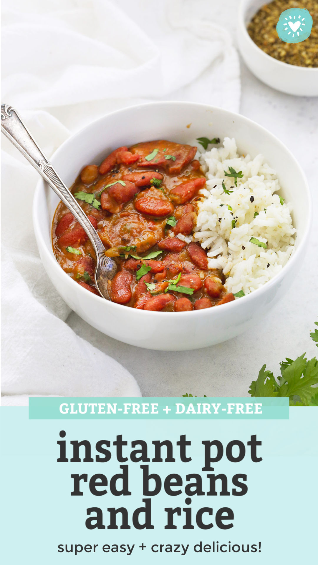 front view of Instant Pot Red Beans and Rice in a bowl garnished with fresh herbs with text that reads "gluten-free + dairy-free Instant Pot red beans and rice. Super easy + crazy delicious!"