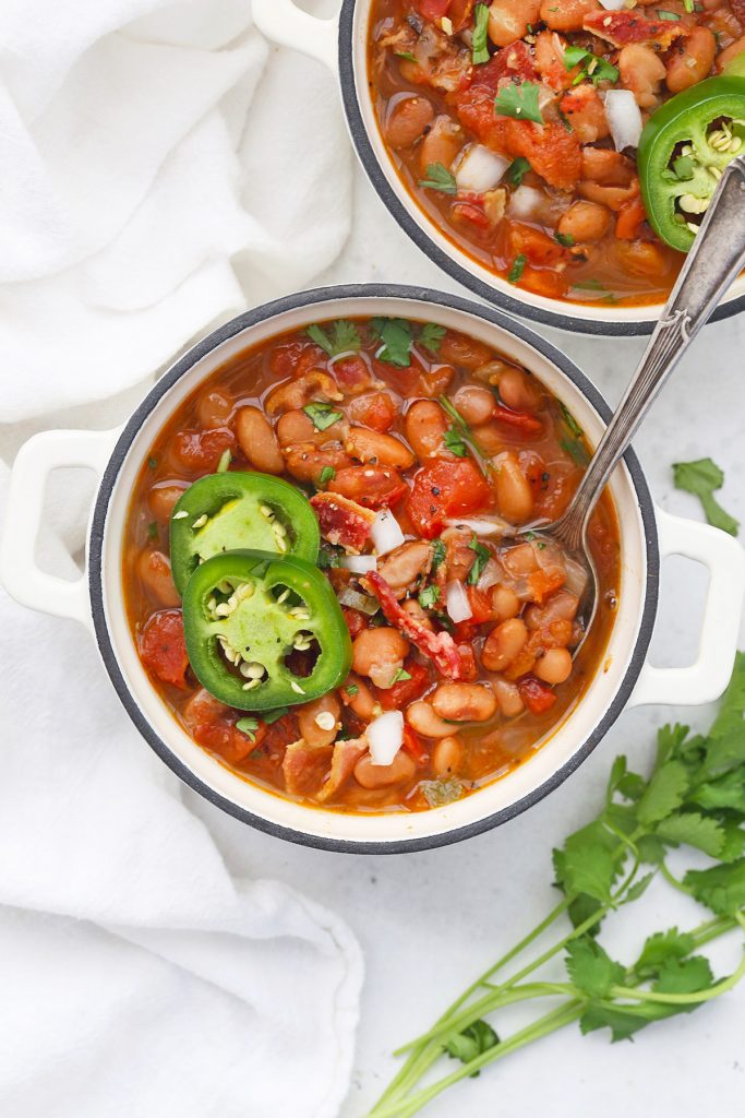 Two bowls of Instant Pot Charro Beans on a white background